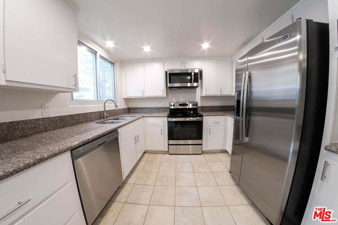 7758 West 91st Street, Unit 2 Playa del Rey, CA 90293 - Photo 2 of 24 a kitchen with stainless steel appliances granite countertop a refrigerator sink and microwave
