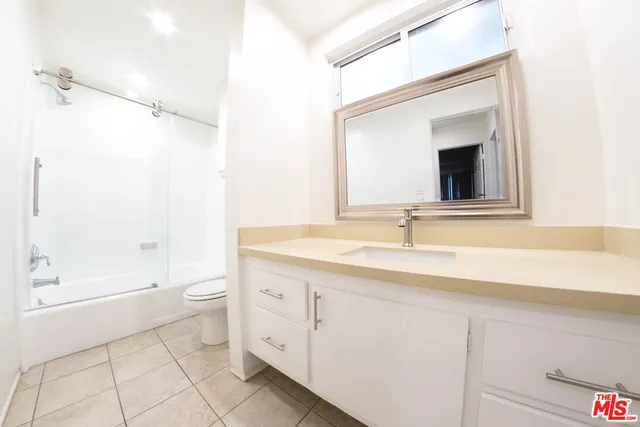 a bathroom with a granite countertop sink a toilet and a bathtub