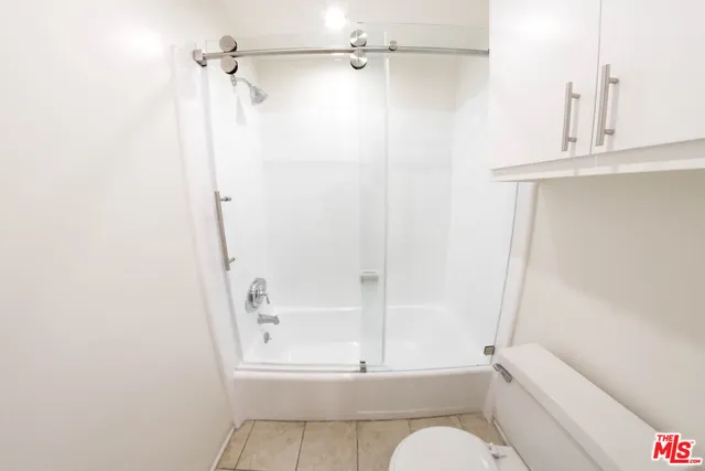 a bathroom with a shower a toilet and a sink