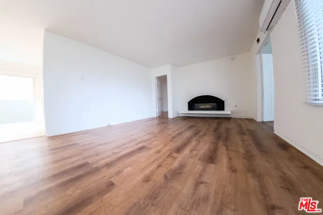 a view of a room with wooden floor and a window