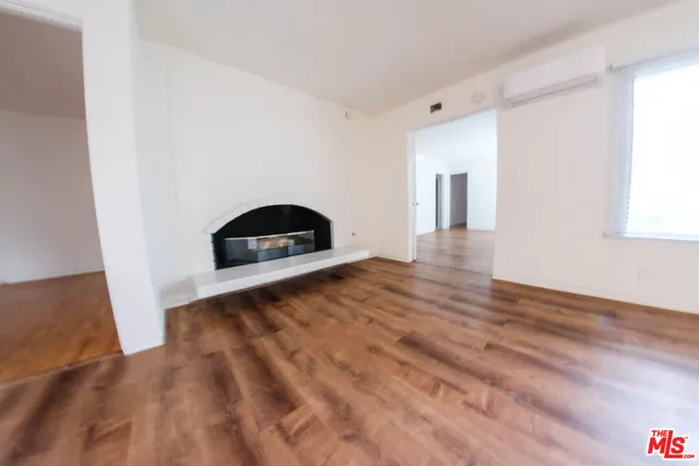 a view of a livingroom with wooden floor and a window