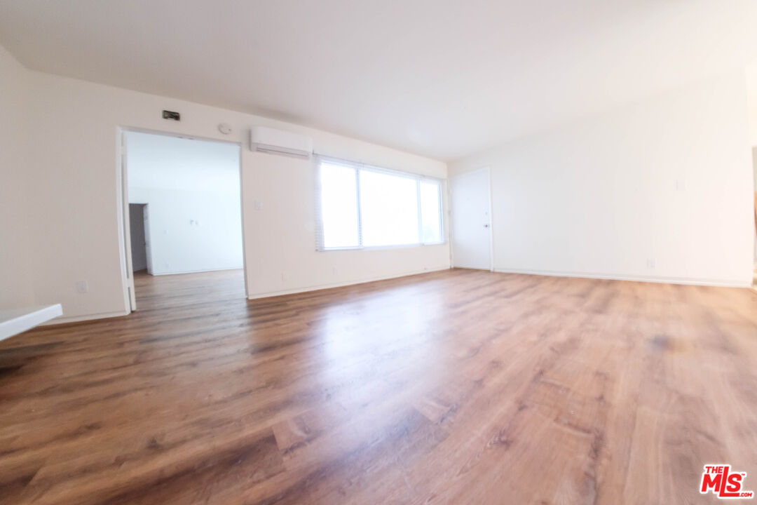 7758 West 91st Street, Unit 2 Playa del Rey, CA 90293 - Photo 5 of 24 an empty room with wooden floor and windows