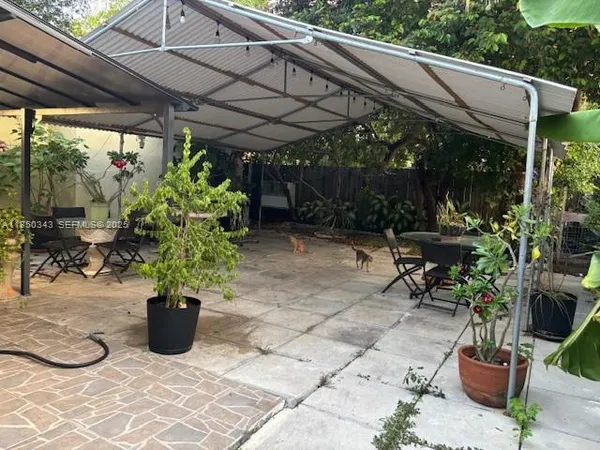 a view of a patio with table and chairs potted plants