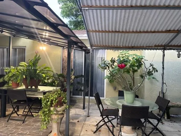 a view of a patio with table and chairs and potted plants