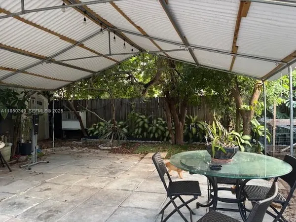a backyard with table and chairs with potted plants