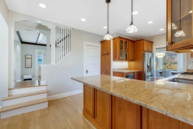 a large kitchen with stainless steel appliances kitchen island granite countertop a sink and cabinets