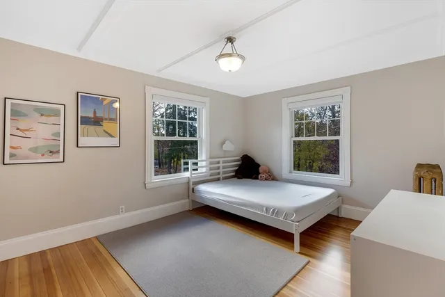 a bedroom with a bed and wooden floor