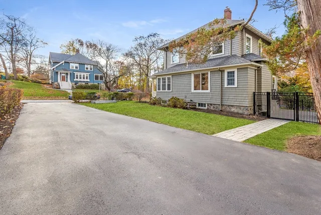 a view of a big house with a big yard and large trees