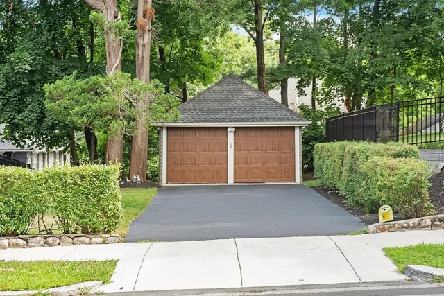 a front view of a house with a yard and potted plants