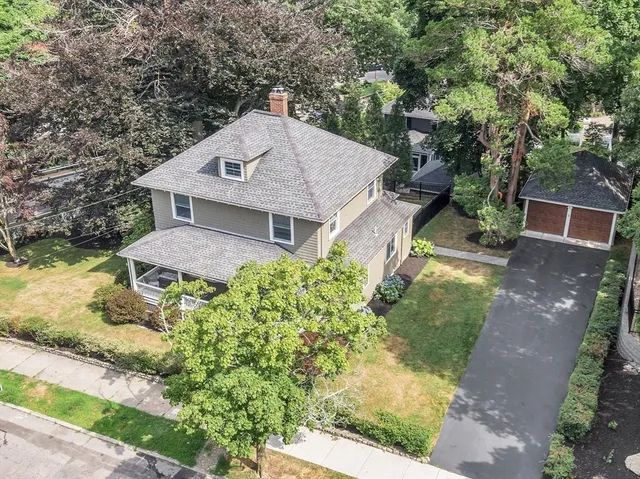 a aerial view of a house with a yard and large trees