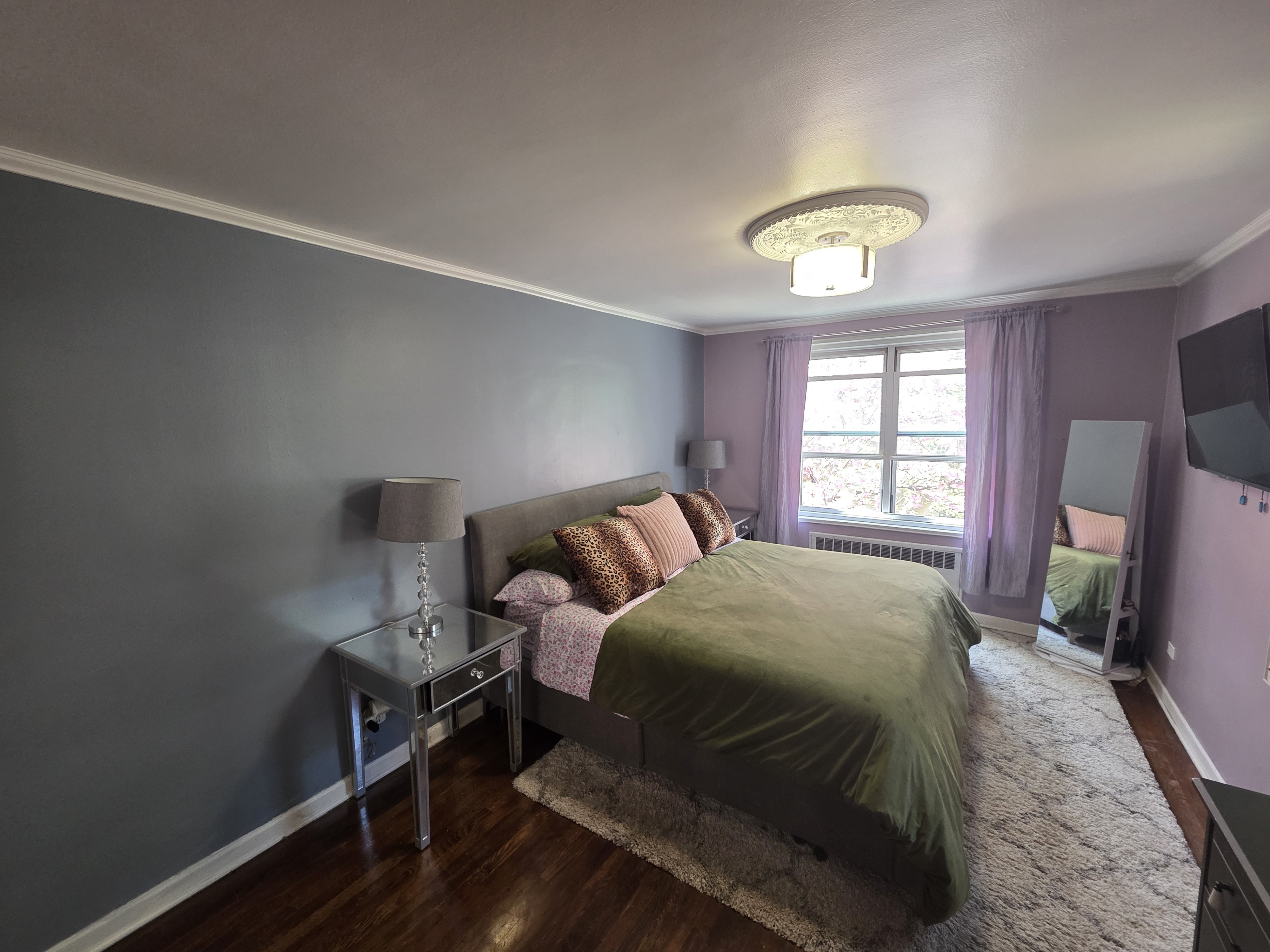 Undisclosed Address Queens, NY 11372 - Photo 5 of 9 a bedroom with a bed and a chandelier