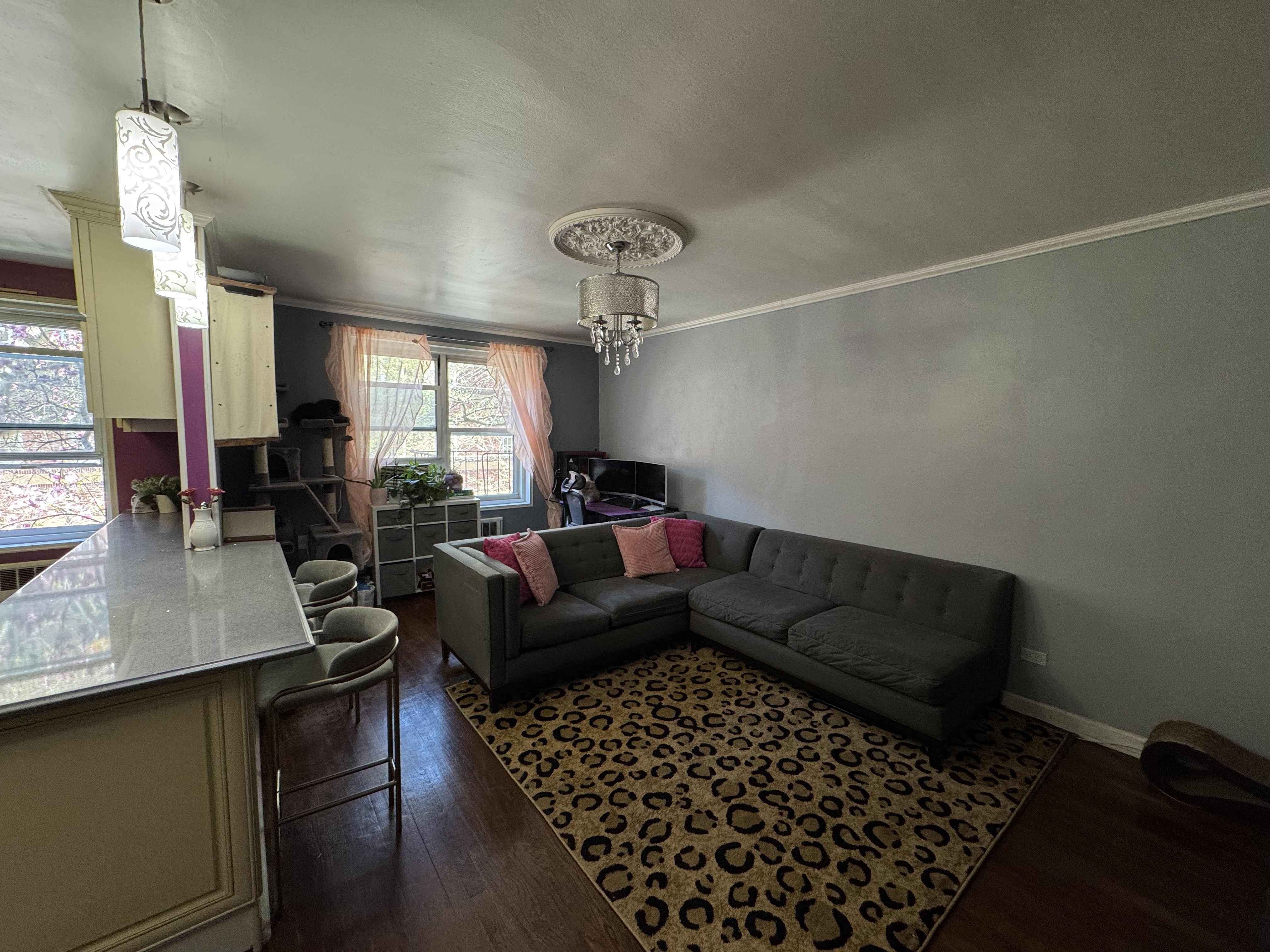 Undisclosed Address Queens, NY 11372 - Photo 6 of 9 a living room with furniture and a chandelier