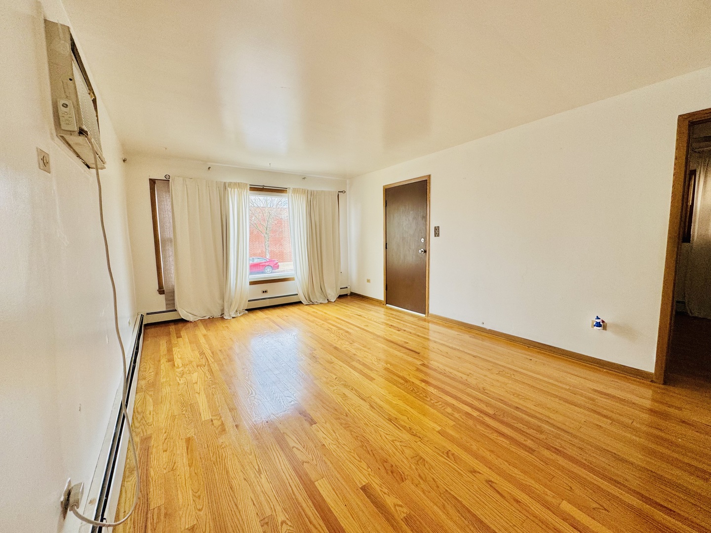 4211 West 63rd Street, Unit 1 Chicago, IL 60629 - Photo 4 of 13 a view of an empty room with wooden floor and a window