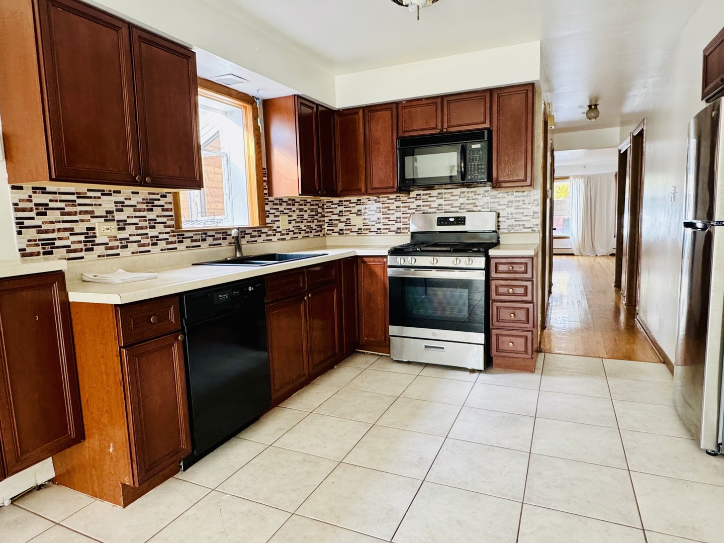4211 West 63rd Street, Unit 1 Chicago, IL 60629 - Photo 6 of 13 a kitchen with stainless steel appliances granite countertop a stove a sink and a microwave