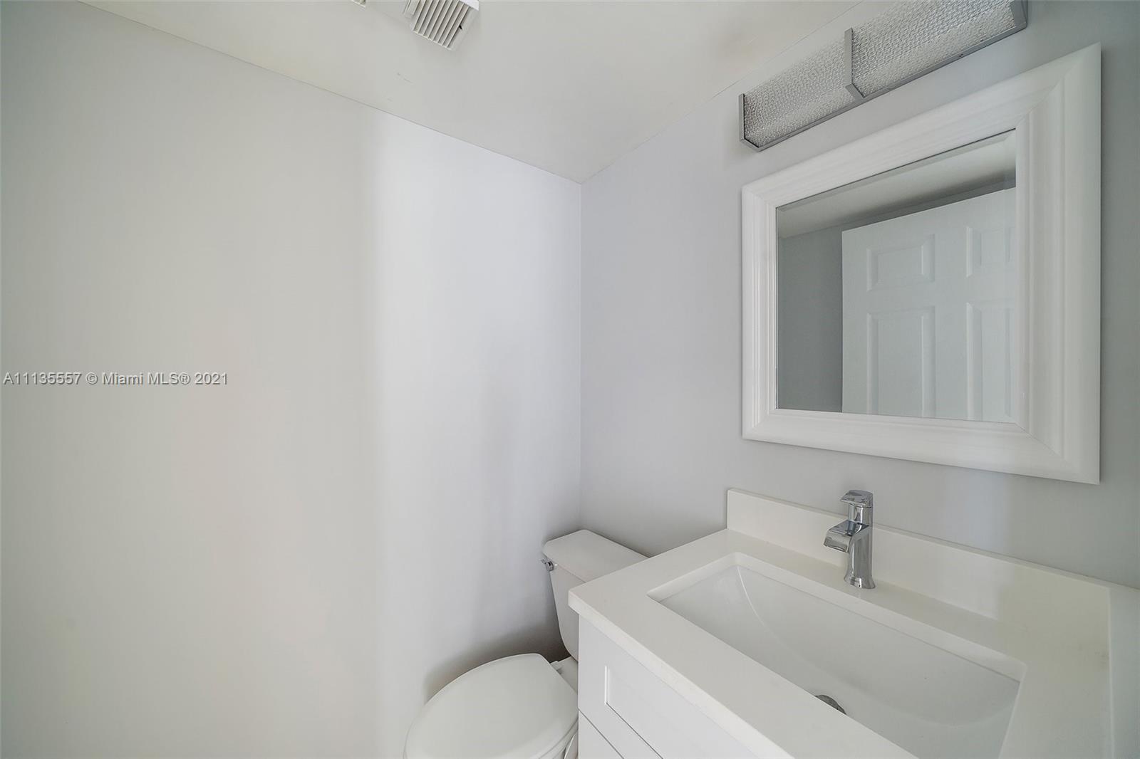 6351 Riverwalk Lane, Unit 4 Jupiter, FL 33458 - Photo 15 of 46 a bathroom with a toilet sink and mirror