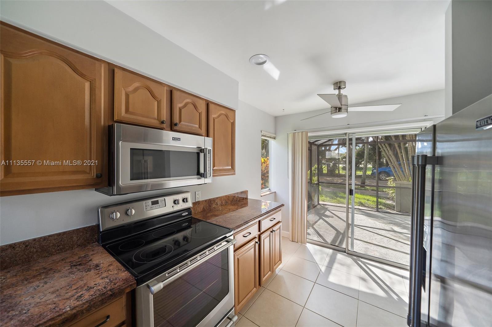 6351 Riverwalk Lane, Unit 4 Jupiter, FL 33458 - Photo 18 of 46 a kitchen with stainless steel appliances granite countertop a stove a microwave and a sink