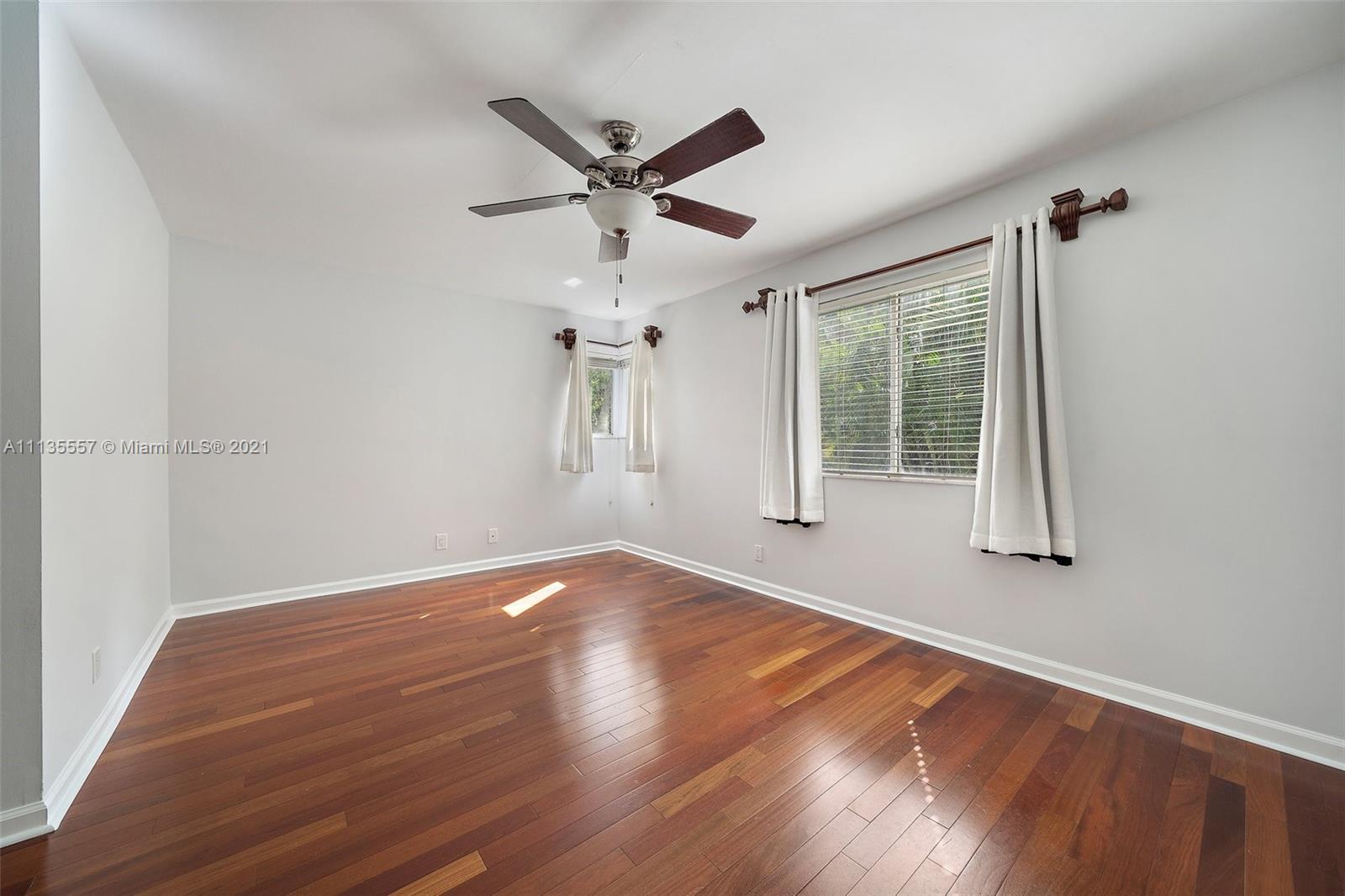 6351 Riverwalk Lane, Unit 4 Jupiter, FL 33458 - Photo 26 of 46 an empty room with wooden floor fan and windows