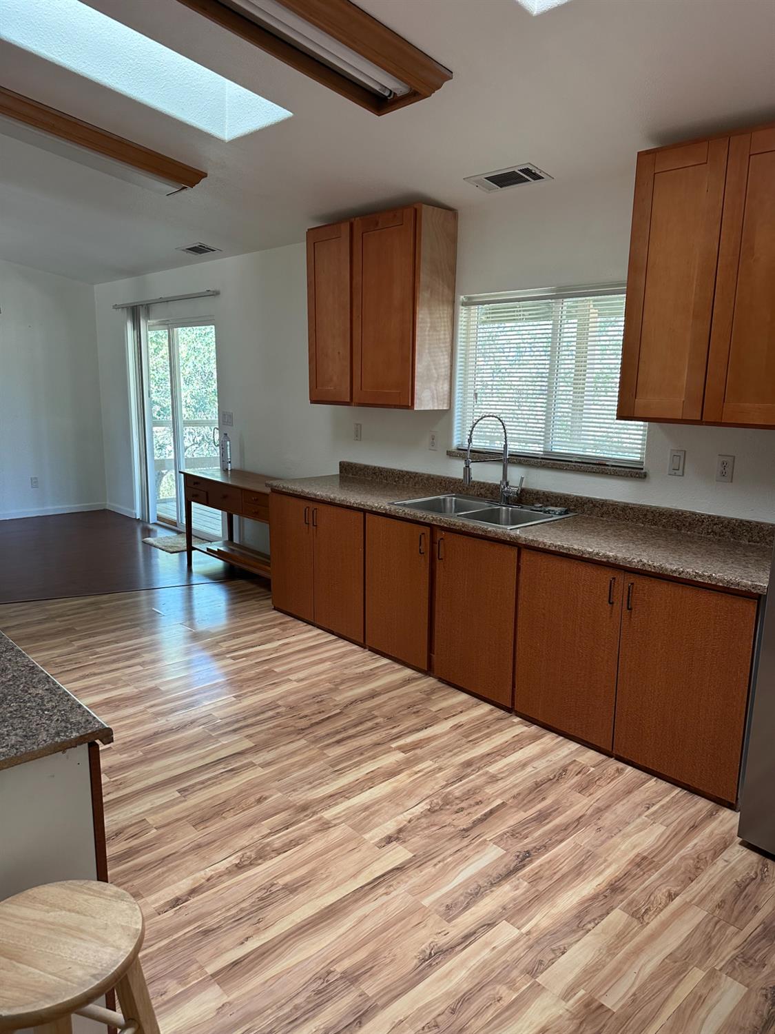 16164 Nugget Road Corning, CA 96021 - Photo 6 of 17 a kitchen with stainless steel appliances granite countertop a sink dishwasher and cabinets with wooden floor