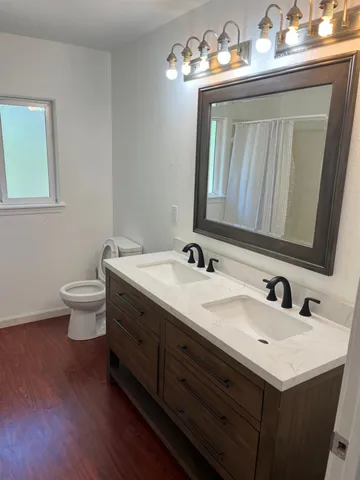 a bathroom with a toilet sink and mirror