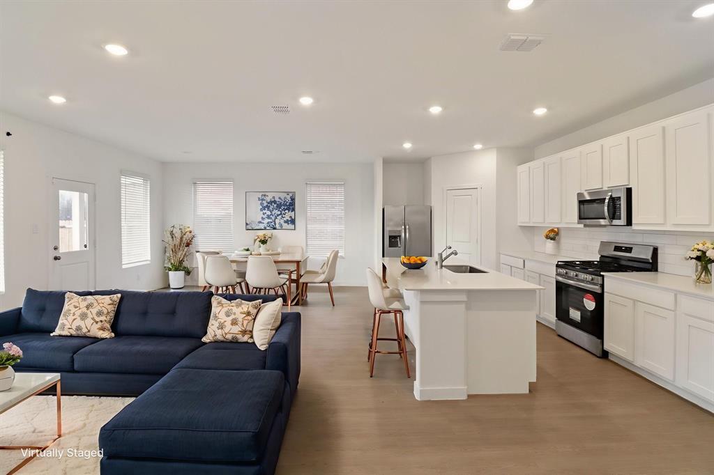 1016 Flameleaf Drive Princeton, TX 75407 - Photo 31 of 32 Kitchen with stainless steel appliances, open floor plan, white cabinetry, recessed lighting, and a center island with sink