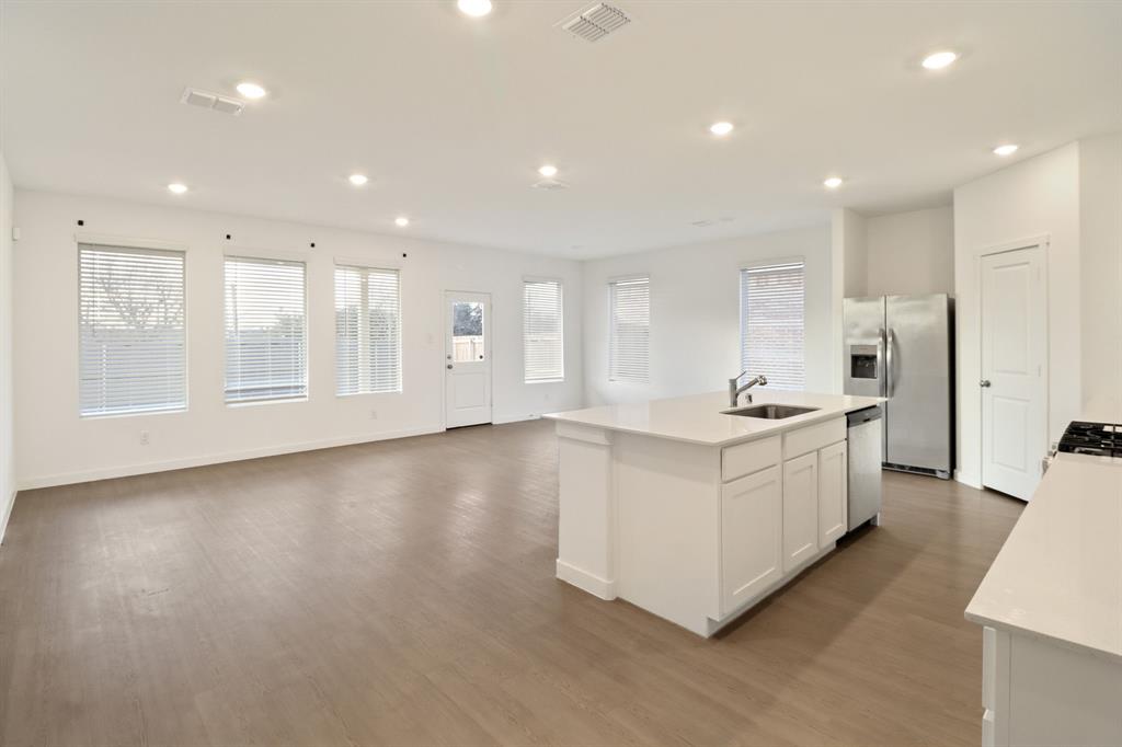 1016 Flameleaf Drive Princeton, TX 75407 - Photo 28 of 32 Kitchen featuring open floor plan, stainless steel appliances, an island with sink, recessed lighting, and light wood-style flooring