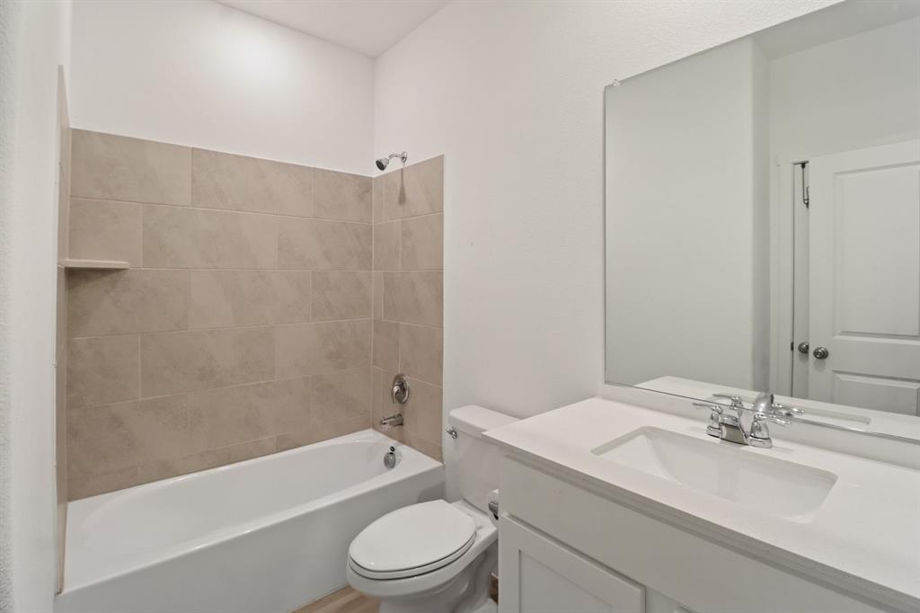 1016 Flameleaf Drive Princeton, TX 75407 - Photo 8 of 32 a bathroom with a granite countertop bathtub shower sink mirror vanity and toilet
