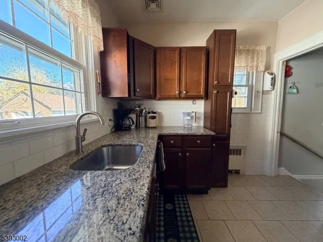 a kitchen with granite countertop a refrigerator and a sink
