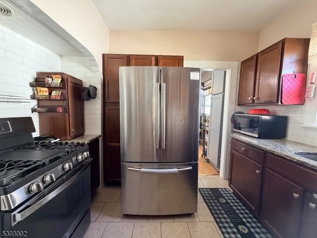 a kitchen with stainless steel appliances granite countertop a refrigerator and a stove