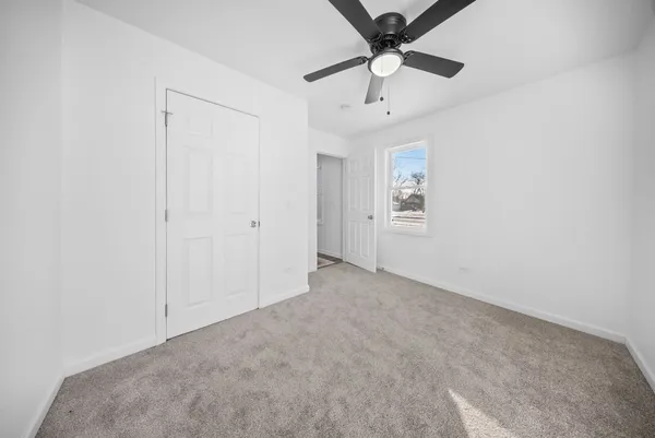 an empty room with chandelier fan