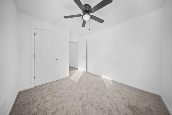 an empty room with a ceiling fan and a window