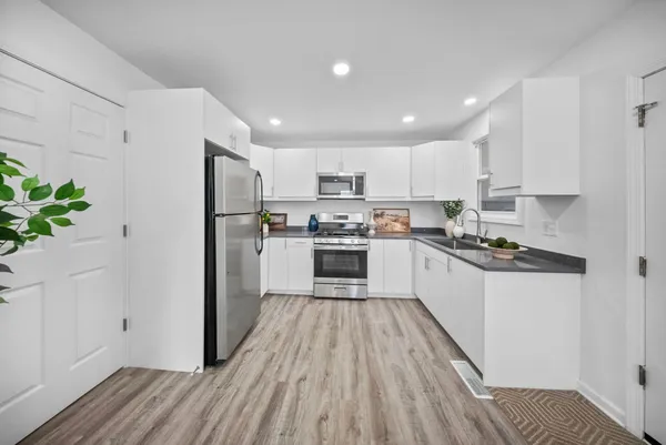 a kitchen with granite countertop white cabinets and stainless steel appliances