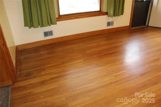 a view of a small space with wooden floor and a window