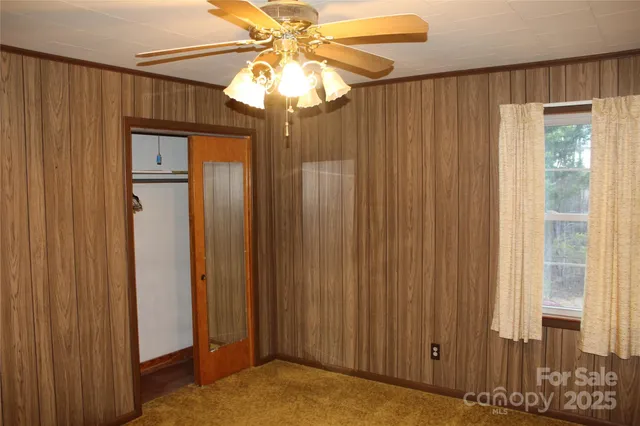 a view of a bedroom with closet and chandelier fan
