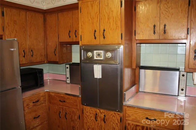 a kitchen with stainless steel appliances granite countertop a refrigerator and a stove