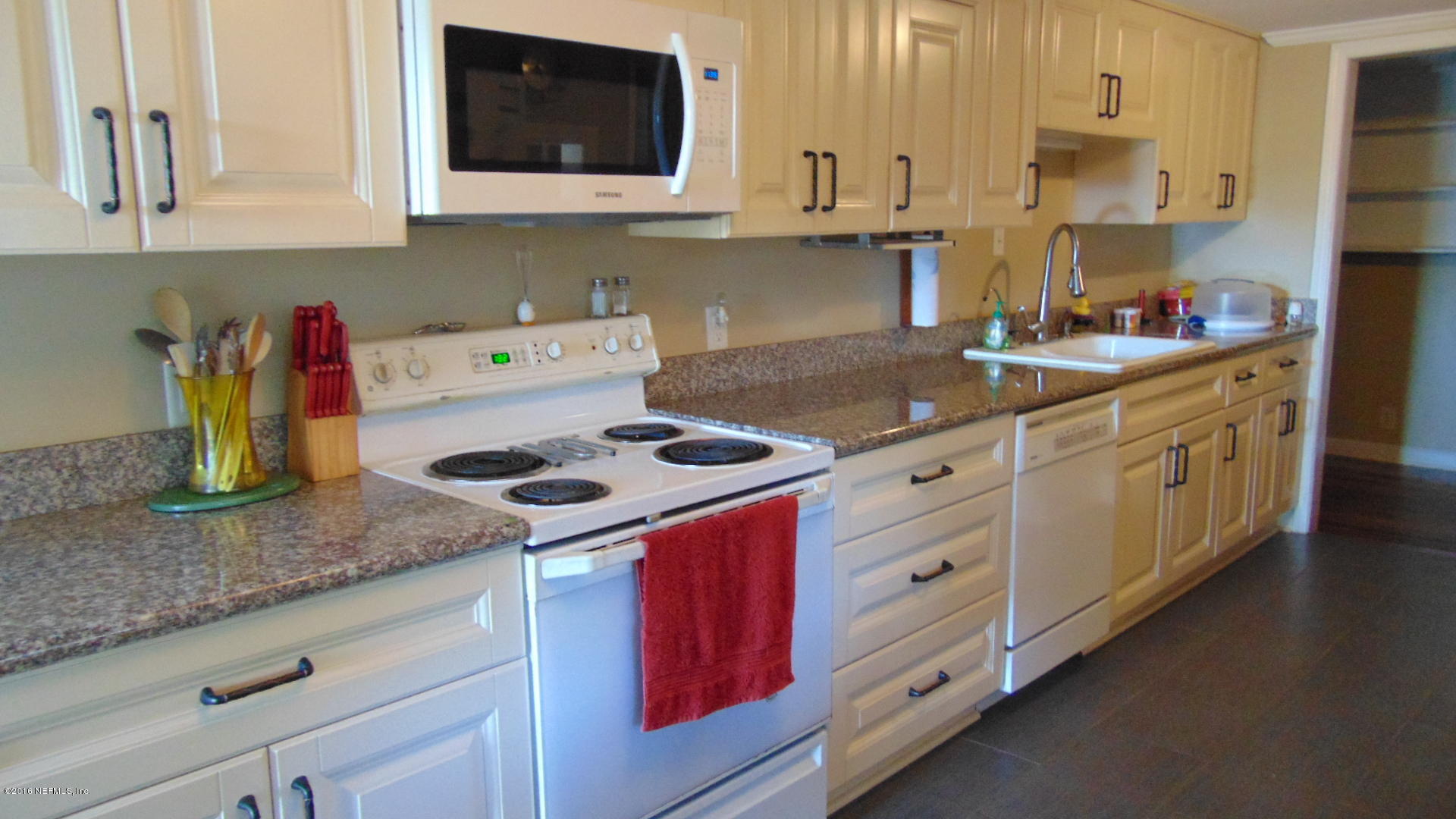 4636 Manchester Road Jacksonville, FL 32210 - Photo 1 of 9 a kitchen with granite countertop a sink a stove and cabinets