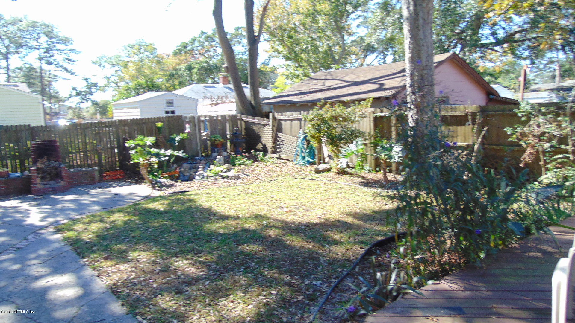 4636 Manchester Road Jacksonville, FL 32210 - Photo 8 of 9 a backyard of a house with table and chairs under an umbrella