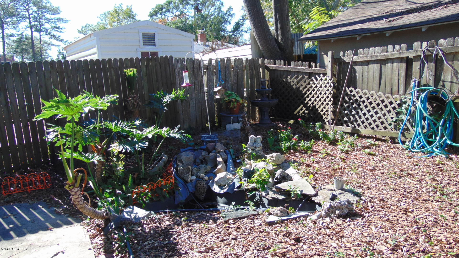 4636 Manchester Road Jacksonville, FL 32210 - Photo 9 of 9 a view of a garden filled with plants and covered with wooden fence