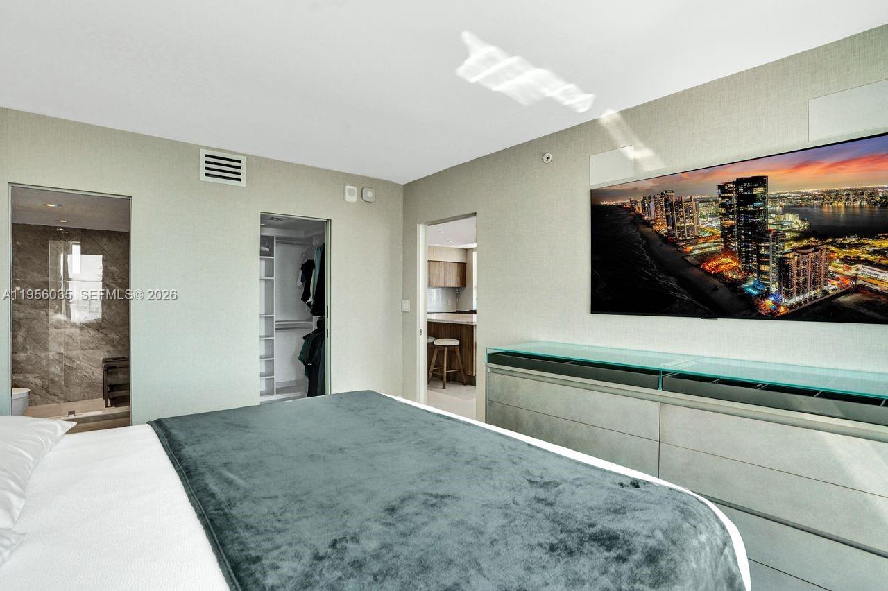 90 Alton Road, Unit 2701 Miami Beach, FL 33139 - Photo 39 of 76 a bedroom with a bed and a flat screen tv
