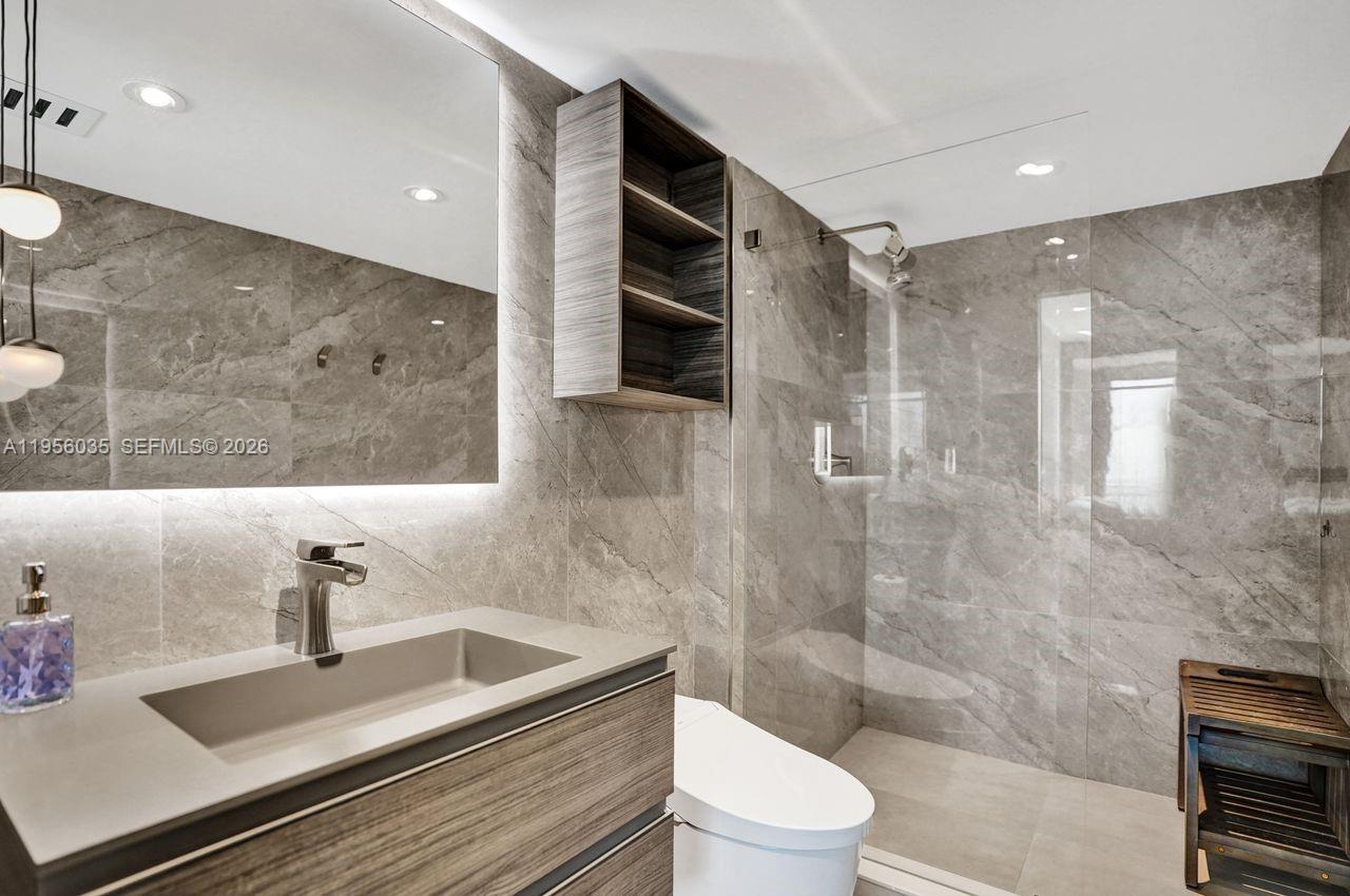90 Alton Road, Unit 2701 Miami Beach, FL 33139 - Photo 47 of 76 a bathroom with a sink a toilet and shower