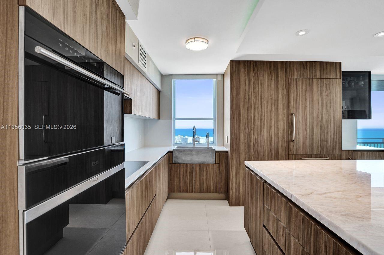 90 Alton Road, Unit 2701 Miami Beach, FL 33139 - Photo 7 of 76 a kitchen with a sink and refrigerator