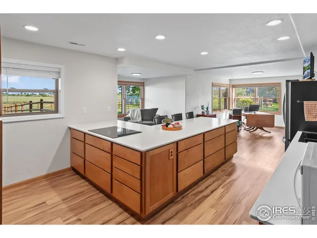 a view of living room with stainless steel appliances granite countertop furniture and a wooden floor