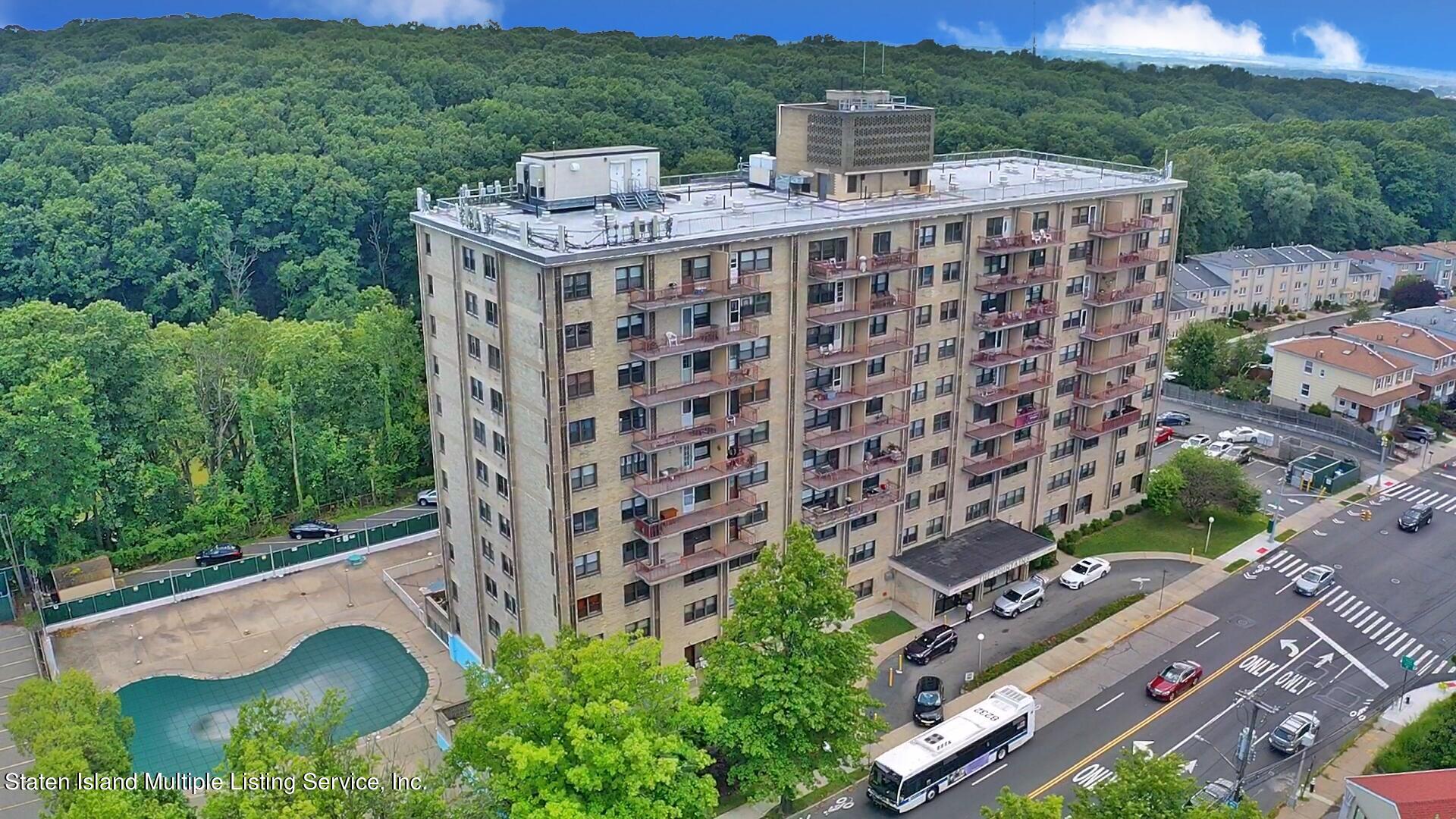 an aerial view of multi story residential apartment building with a yard