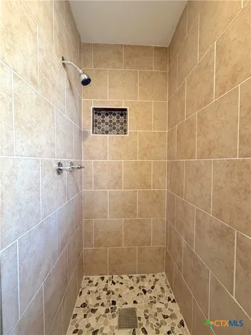 a large kitchen with a center island wooden floor stainless steel appliances and cabinets