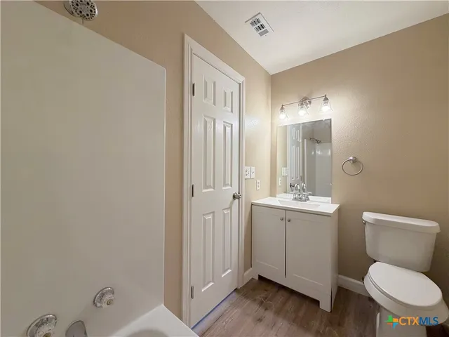 a view of a kitchen with wooden floor and electronic appliances