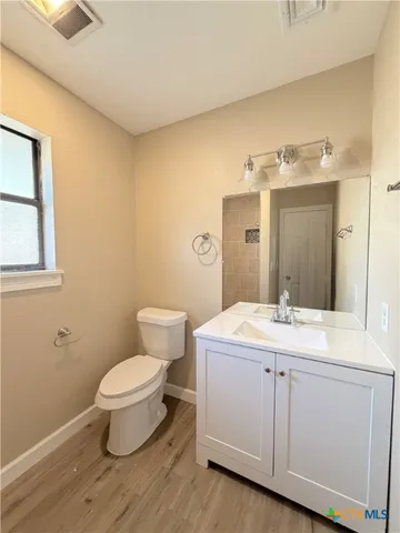 a kitchen with granite countertop wooden floors appliances a sink and cabinets