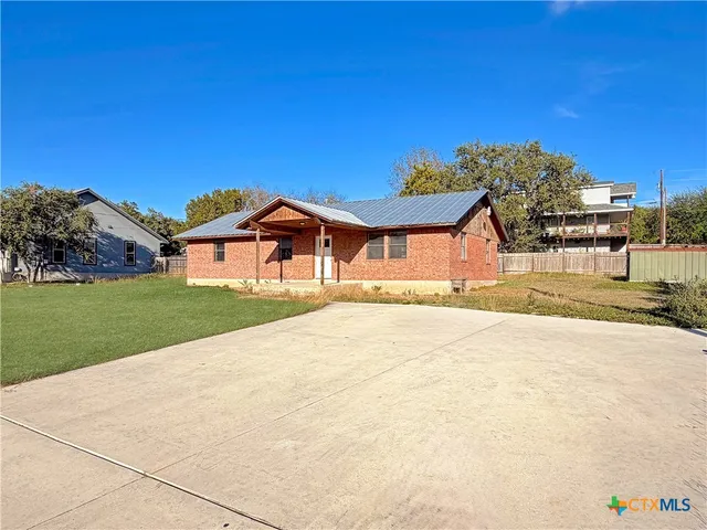 an empty room with wooden floor ceiling fan and windows