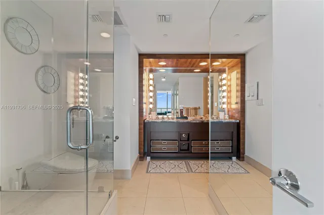 a bathroom with a glass shower door and mirror