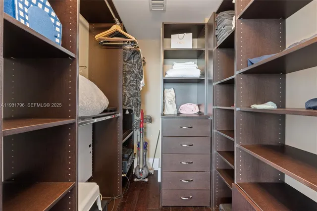 a view of walk in closet with clothes and shoes