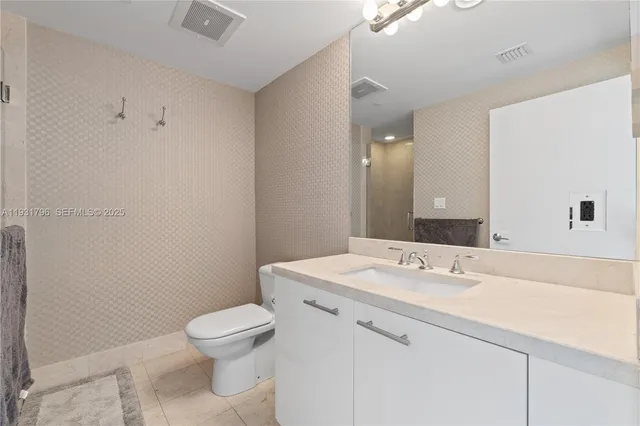 a bathroom with a sink a toilet and mirror