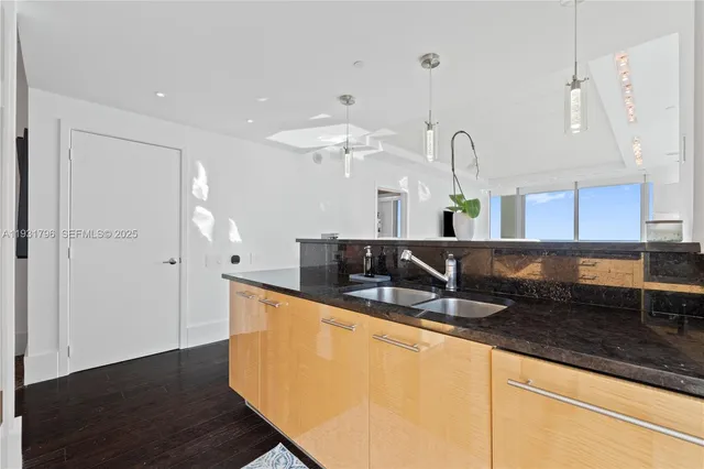 a kitchen with stainless steel appliances granite countertop a sink a refrigerator and a granite counter tops